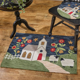 Chapel On The Hill Hooked Rug 24x36 with a church and sheep design on a wooden floor.