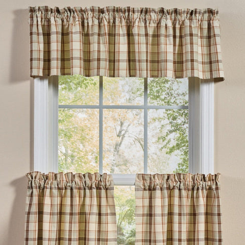 Toffee & Elm Plaid Valance featuring a beige, brown, and green tartan pattern, shown hanging on a white-framed window.