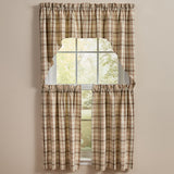 A set of beige green and brown Toffee & Elm Plaid Cafe Tiers and Swags, including a top panel and two tier panels, styled on a window against a neutral beige wall.