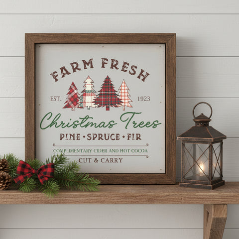 Farm Fresh Christmas Trees wood sign in rustic brown frame displayed on a farmhouse shelf with a lit lantern, pine branches, pinecone, and red plaid bow