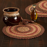 Autumn Blaze Braided Trivet 15" Set of 3 with Ceramic pot, wooden spoons, and bottle on braided placemats on a wooden surface