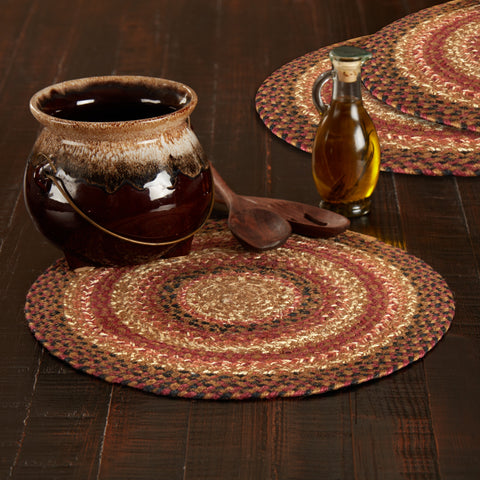 Autumn Blaze Braided Trivet 15" Set of 3 with Ceramic pot, wooden spoons, and bottle on braided placemats on a wooden surface