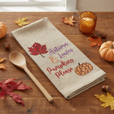 Square fall lifestyle image of the September Leaves Dishtowel on a wood table