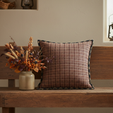 Brick Raven Fabric Pillow with fall florals on a wood bench