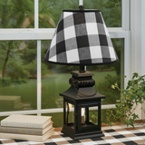 Black lantern lamp with black-and-tan runner and books