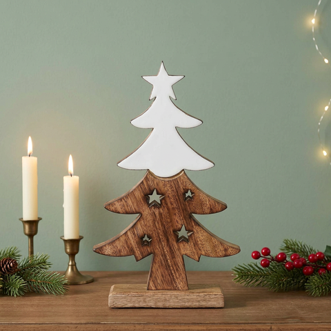 Wooden Christmas tree figurine with a sage green wall and candle accents
