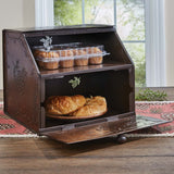 Copper Pine Bread Box crafted from antiqued copper tinderbox brown metal with embossed pinecone motifs shown with muffins and rolls. 