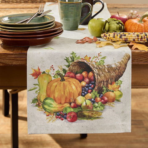 Table setting with Cornucopia Fall Table Runner 54" featuring pumpkins, cornucopia, and fruits on a wooden table.