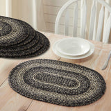 Black and cream Farmstead Black Braided Placemat - Set of 6 on a wooden table with white plates and cutlery.