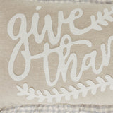 Close-up of Give Thanks cursive appliqué on natural cotton chambray with cream leaf sprig border detail and grey buffalo check ruffle edge