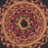 Close-up macro of Heirloom Farm Braided Trivet showing tightly woven mustard tan, burgundy, and raven black jute blend braids spiraling from center