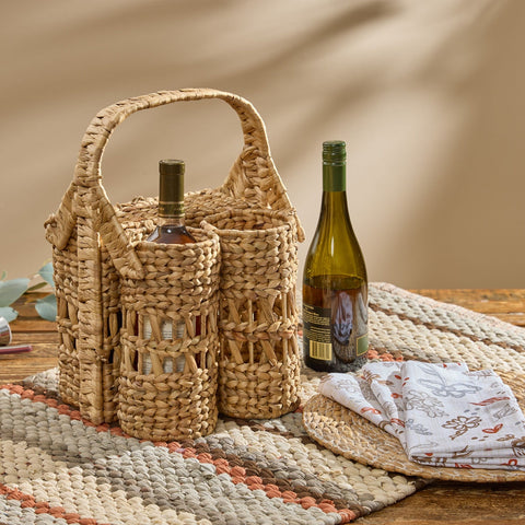 Cinthia Hyacinth Wine Basket Caddy with three compartments and arched carry handle, natural tan woven water hyacinth, wine bottle on farmhouse table