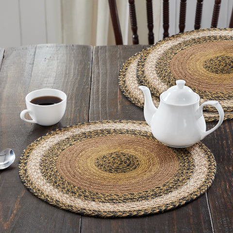 Kettlehurst Braided Trivet 15" Set of 3 Round woven placemats on a wooden table with a teapot and cup.