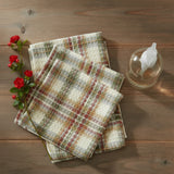 Lemoncrest Dishcloth Set of 3 folded waffle-weave dishcloths with a cream, green, and red plaid pattern are arranged on a rustic wooden table next to a clear glass bottle with a white pump.