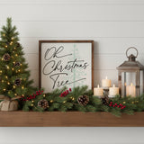 Oh Christmas Tree Holiday Sign 10x10 A square framed decorative sign with the phrase “Oh Christmas Tree” in black script over a pale green Christmas tree illustration on a light background, set in a dark brown wood frame.  Displayed on a wood mantel with mini Christmas tree, pine boughs, lantern and candles.