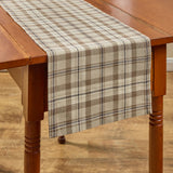 Tinderbox Brown Plaid Table Runner draped on a rustic wood farm table showing full length and hem overhang — farmhouse cotton plaid in tinderbox brown, oatmeal and espresso