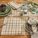Tinderbox Brown Plaid Table Runner layered with matching plaid placemats on a farmhouse wood table, styled with green stoneware, plaid napkins, windmill napkin rings, and eucalyptus greenery